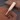 Leather tool with wooden handle and brass components on a leather surface
